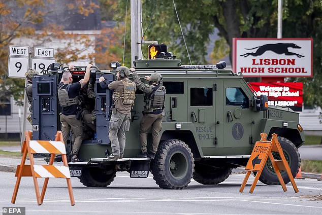 A tactical police unit makes its way down a street during the search for mass shooting suspect Robert Card in Lisbon Falls, Maine, U.S., October 26, 2023