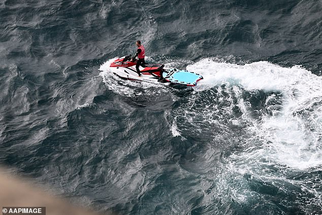 A jet ski could be seen hovering on the rocks as the rider waited for a boat to arrive on the scene