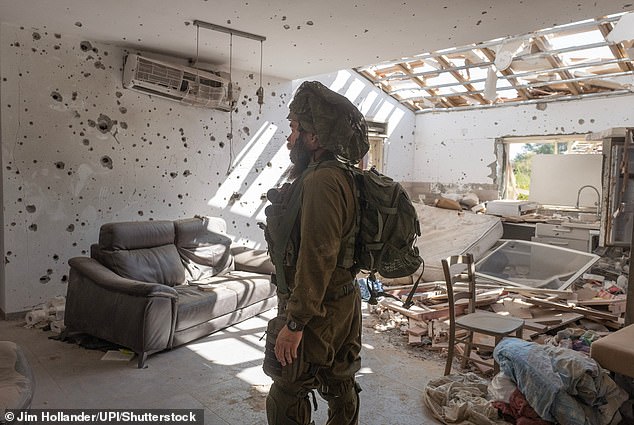 An Israeli soldier inside the destroyed Jewish home in the Kibbutz Be'eri community along the border with the Gaza Strip