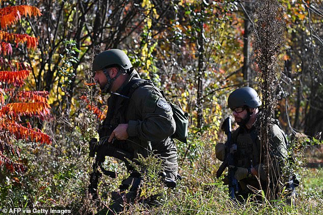 Law enforcement personnel approach a home in Monmouth, Maine, on October 27, 2023, in the aftermath of a mass shooting in Lewiston