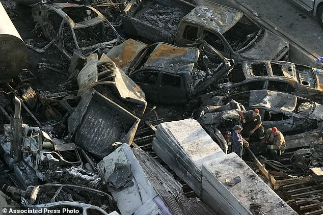 Emergency workers are seen near wreckage in the aftermath of a multi-vehicle crash on I-55 in Manchac