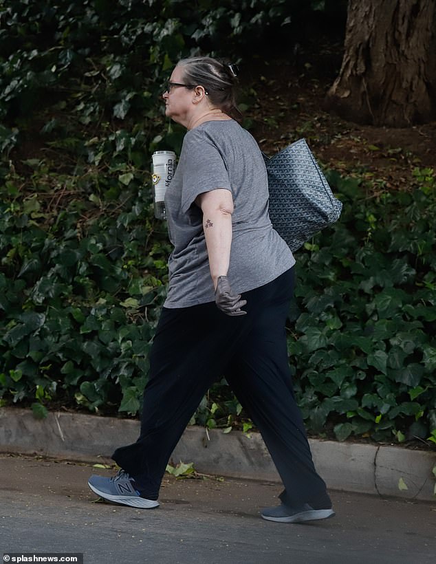 She carried two cups in her gloved hand and slung a bag over her shoulder