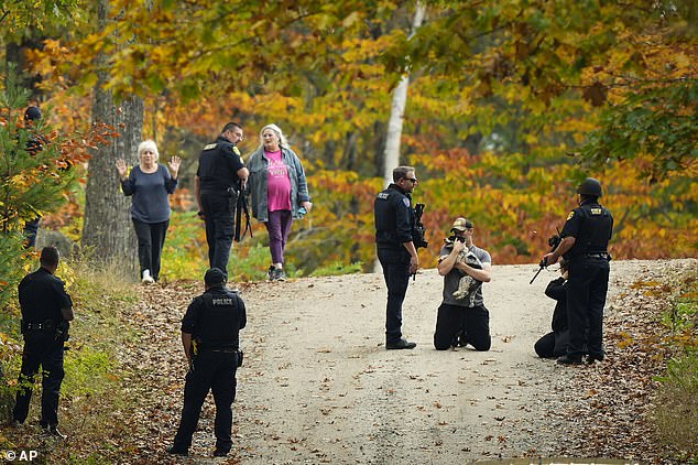 Law enforcement officers temporarily detain people as manhunt continues in the aftermath of a mass shooting in Durham, Maine, Friday, October 27, 2023