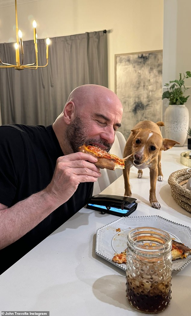 Four-legged family;  There's also a new photo of Travolta sharing a slice of pizza with Peanut while sitting at the dining room table of his Florida home