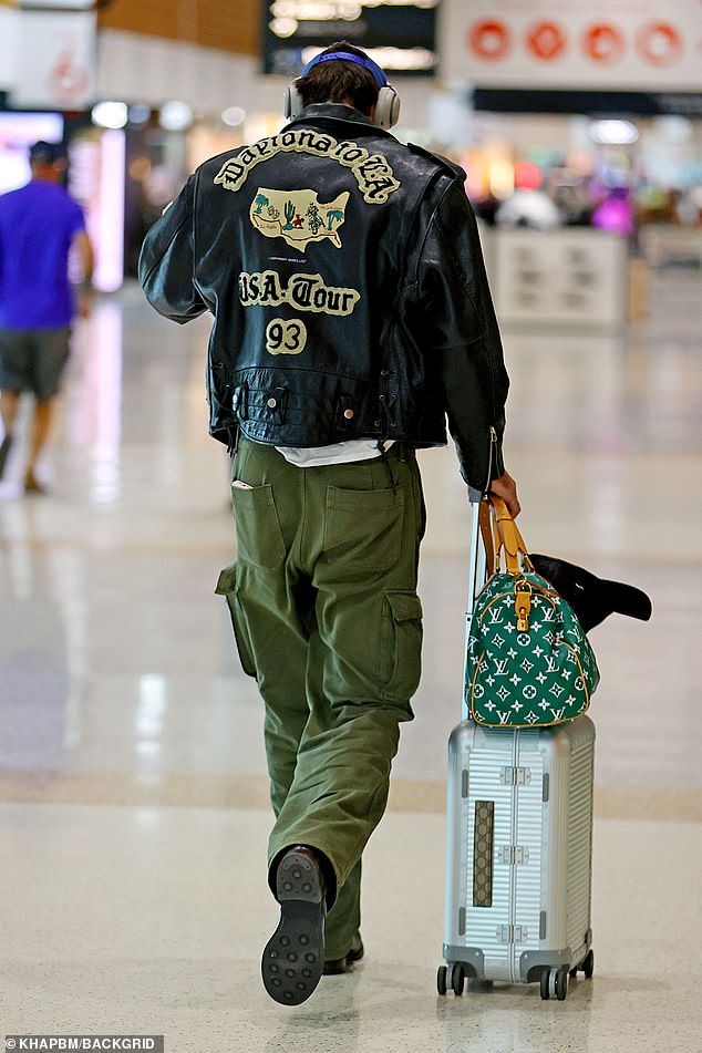 He then took off through the terminal, passing by a Louis Vuitton sports backpack and a silver tote bag