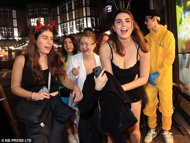 Partygoers in different outfits go out into the night to celebrate Halloween