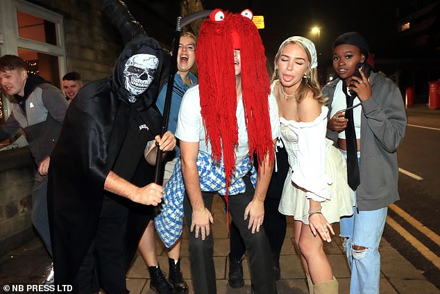 A MSN in a striking red wig is joined by his friend dressed as death and a woman in a pirate costume