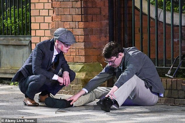 Two boys dressed as characters from Peaky Blinders take some time to reflect after a tough night out in Birmingham