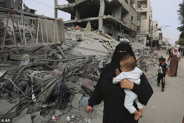 Families pass scenes of destruction in Gaza on Saturday morning after Israel carries out its most intense bombing campaign yet following the October 7 attacks