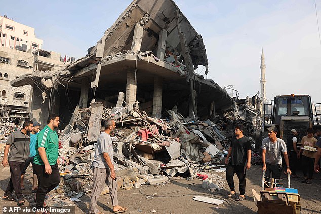 People gather in the streets of the Al-Shatee refugee camp in northern Gaza, which was heavily bombed by Israel overnight into Saturday