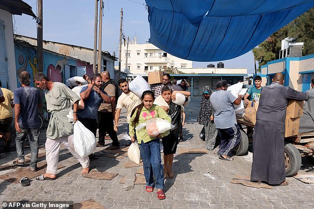 Palestinians transport food aid from a UN-run supply center