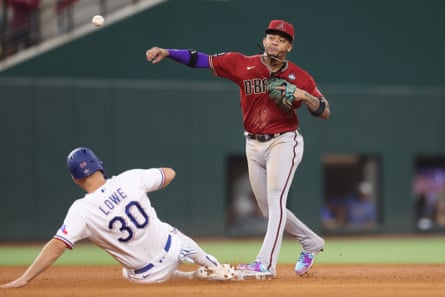 Arizona second baseman Ketel Marte, right, turns a double play as the Rangers' Nathaniel Lowe slides into second base during the 10th inning of Friday's Game 1.