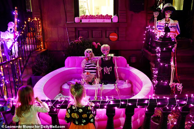 One person has playfully propped up two skeletons in the front yard: one is a blonde wearing a striped swimsuit with a raffia-woven holiday bag, the other in a sleeveless shirt that says 