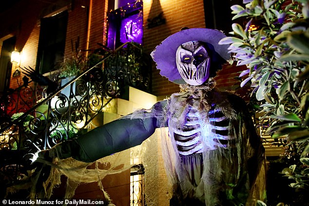 A skeleton ghost stares down at passersby on the street