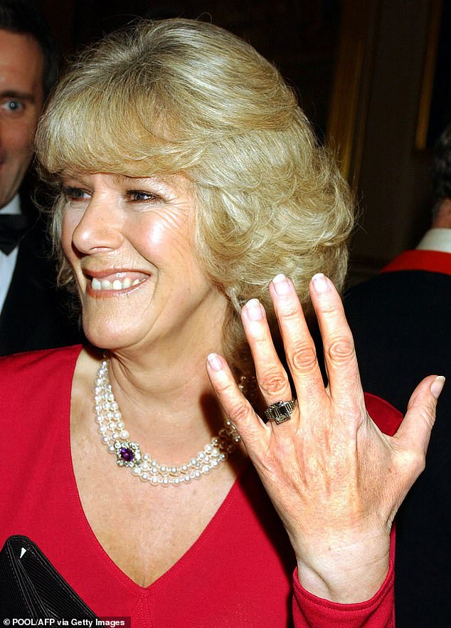 Camilla shows off her engagement ring as she and Prince Charles arrive for a party at Windsor Castle after announcing their engagement on February 10, 2005.