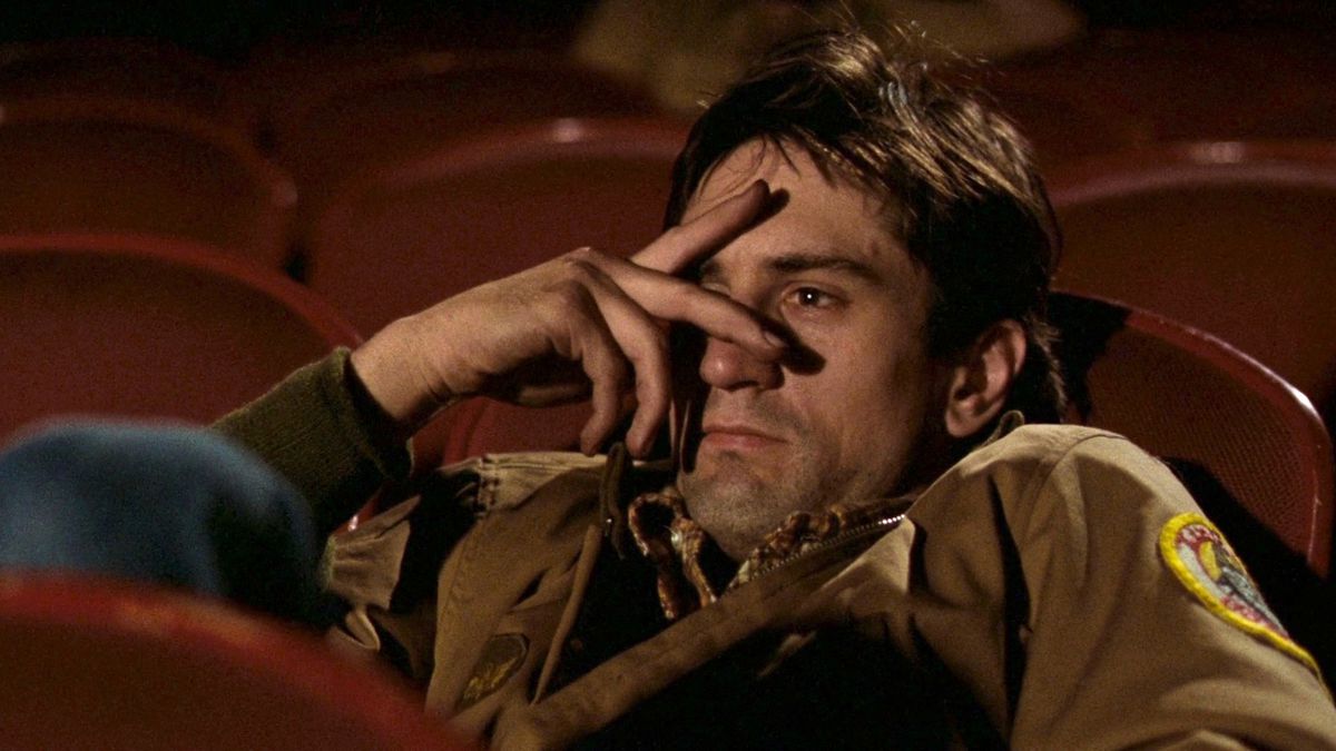 Robert De Niro collapsed in a theater chair with his hand resting against his nose and temple in Taxi Driver.