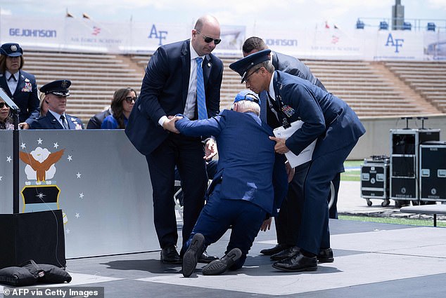 The president is helped to his feet after a fall during the graduation ceremony at the United States Air Force Academy in Colorado