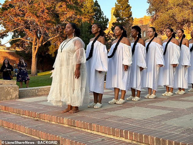 The California-born creator of the BlackLivesMatter hashtag led a procession of nine women as they walked from the UCLA Mildred E. Mathias Botanical Garden to the Fowler Museum in a Los Angeles spectacle watched by thousands of people