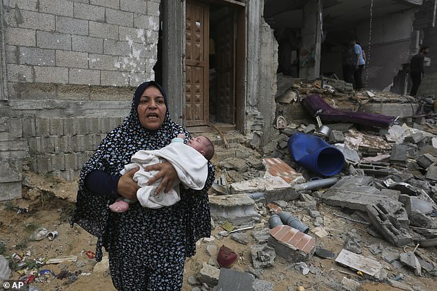 Palestinians evacuate a building destroyed during the Israeli bombardment of the Gaza Strip, including in the southern border town of Rafah