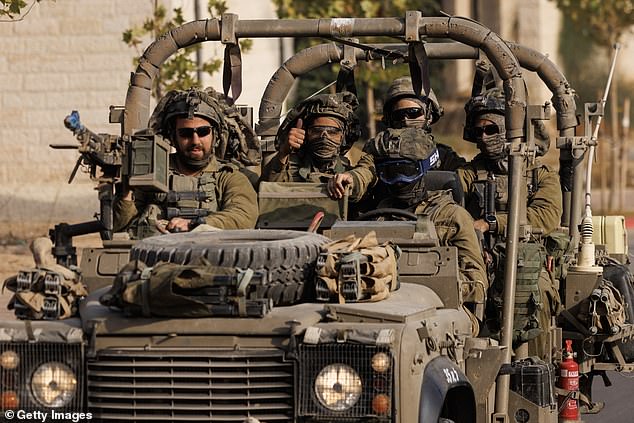 An Israeli soldier gives a thumbs up as Israeli troops approach the Gaza border on Saturday