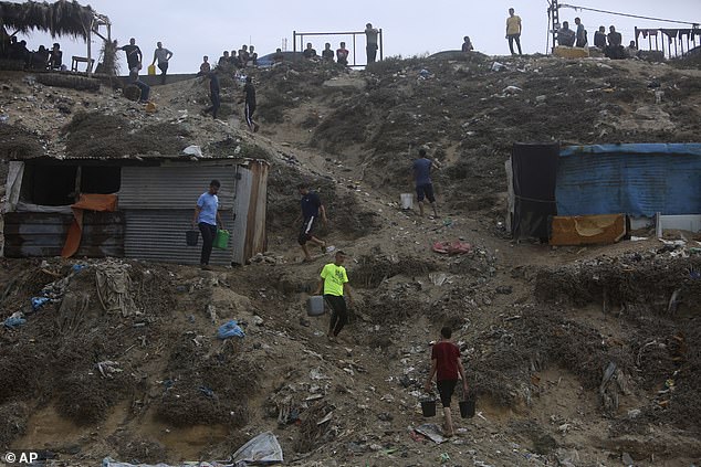 Palestinians collect buckets of water from the sea on Sunday due to the ongoing water shortage in the Gaza Strip