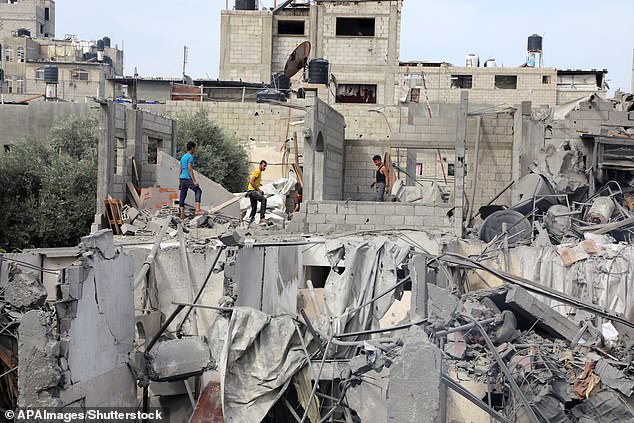 Palestinians search the rubble of buildings destroyed during an Israeli airstrike on El-Nuseirat, central Gaza Strip