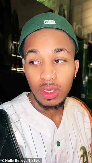 The 26-year-old rapper wore a green hat and a white sports jersey