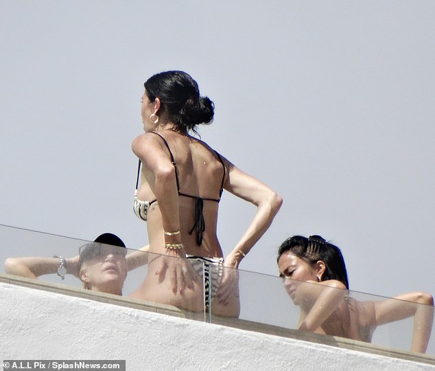 Cheeky: At one point she appeared to put on a spicy display, turning around and grabbing her derriere, as some friends joined her on the roof