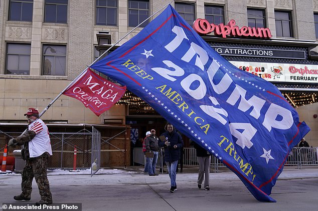 Charles Hibbs of White River, South Dakota, carries a flag outside a Trump rally