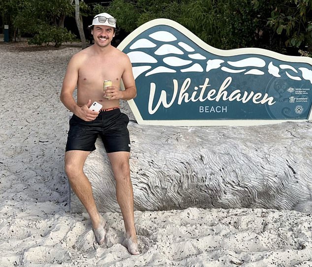 The wannabe plumber kicks back with a can of beer on Whitehaven Beach, above