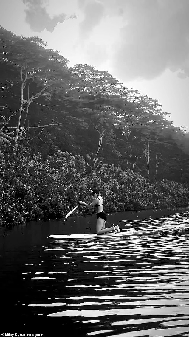 Self-paddling: Miley paddled herself on the calm water with heavy brush on the banks