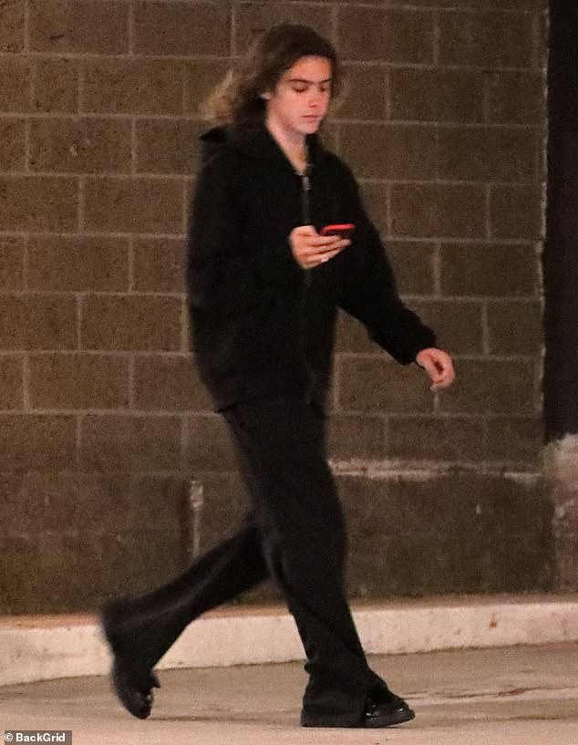 Tracksuit: The Australian singer and songwriter, 21, looked comfortable in a black tracksuit and sneakers.  His brown, wavy hair hung loosely around his shoulders