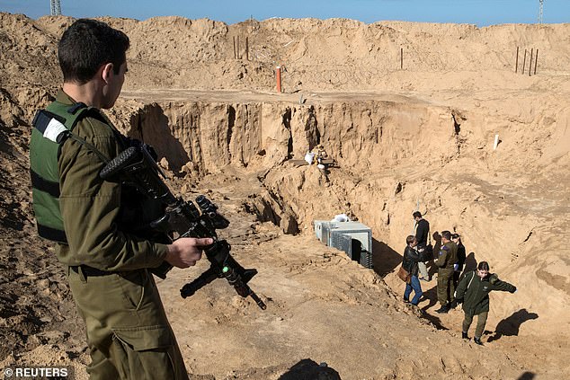 An Israeli soldier stands guard next to an entrance to what the Israeli army says is a cross-border attack tunnel dug from Gaza to Israel near Kissufim on January 18, 2018