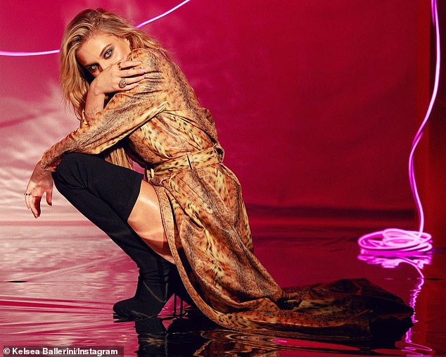 Sultry photo: As part of the photoshoot, she also modeled an animal print trench coat dress, paired with velvet over-the-knee boots in a sultry shot