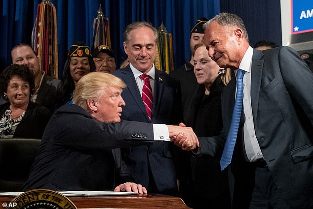 Perlmutter (right) shakes hands with former President Donald Trump.  The ex-Marvel CEO said he was fired for pushing too hard to cut costs