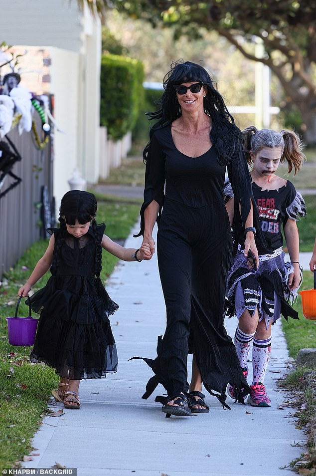 She completed her look with a long black wig and black sunglasses