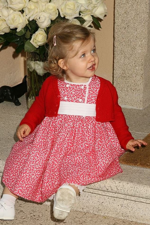 Leonor is seen as a baby sitting on the steps of the palace in one of the many new photos shared by the palace