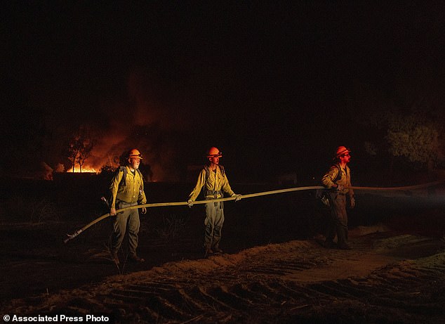 Firefighters hold the hose as they battle the latest Highland Fire in Southern California