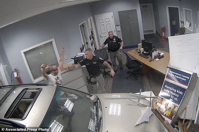 In this image, taken from a video released by the Warren County Prosecutor's Office, police detain John Hargreaves, 34, after he drove his SUV through police headquarters in Independence Township, NJ on September 20.