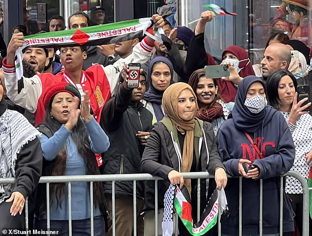 One of the hundreds of placard-clad protesters was seen in the front line holding aloft a swastika