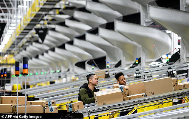 The e-commerce giant reported sales of $143.1 billion for the three months to September (Photo: Workers at an Amazon distribution center in New York)