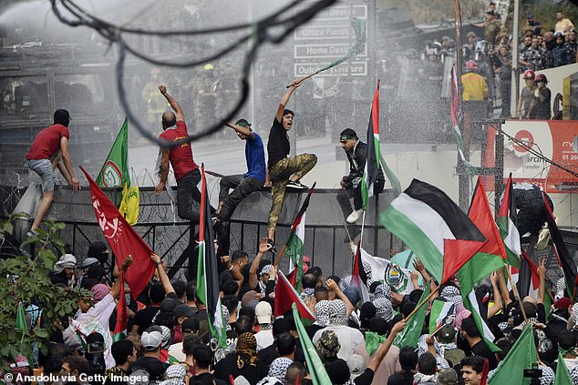 Protesters, carrying the Palestinian flag and banners, gather in front of the US embassy in Beirut, Lebanon, after the Iran-backed Hezbollah called for a day of protests following Tuesday's hospital explosion in Gaza