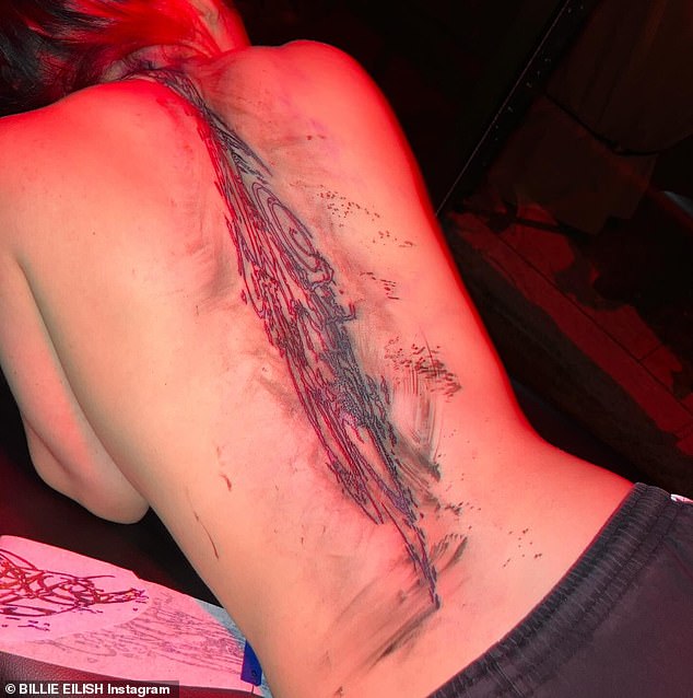 Fresh ink: Among the snaps, Eilish, 21, included a picture of a huge new tattoo on her back, which angered some of her 110 million followers