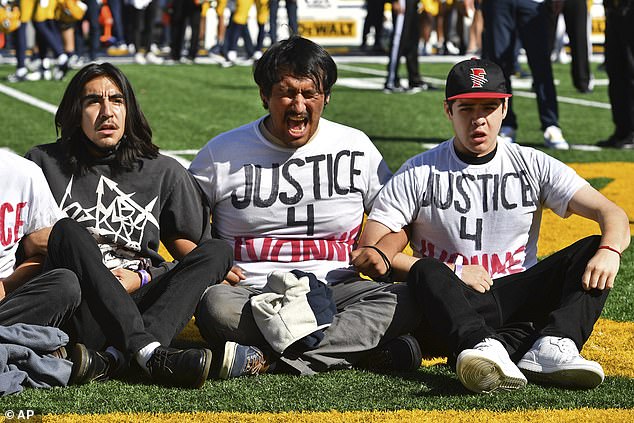 Fifteen people, mostly Cal Berkeley students, postponed the kickoff of a football game in protest