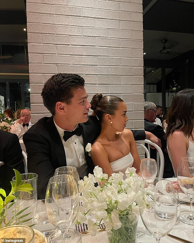 The outdoor ceremony was followed by a sit-down dinner, with the bride and groom looking absolutely in love at a table decorated with white flowers.