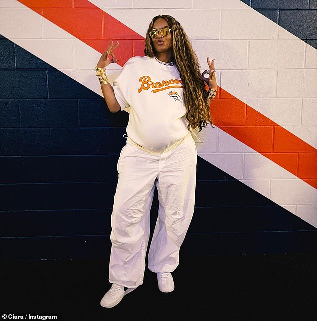 Team spirit: Ciara, 37, showed off her gameday vibes and growing baby bump in a white Denver Broncos sweatshirt, white pants and sneakers as she watched husband Russell Wilson and his teammates beat the Green Bay Packers 19-17