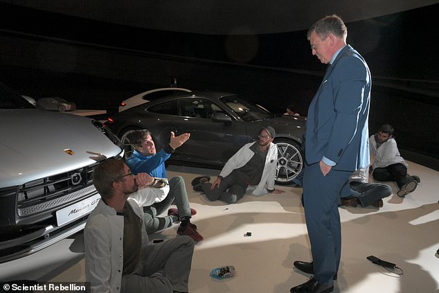 The group of nine activists from the Scientist Rebellion group taped their hands to the floor of Autostadt, a Volkswagan museum in the northern city of Wolfsburg, Germany