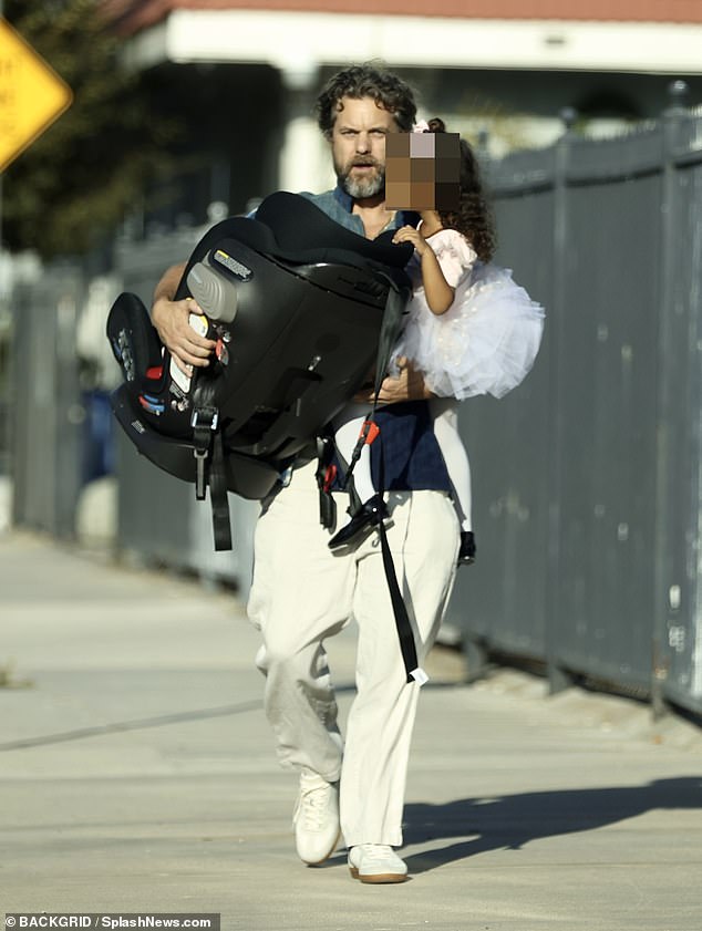 Tough time: Joshua Jackson looked glum as he stepped out with his toddler daughter on Monday - as it emerged his wife Jodie Turner-Smith had filed for divorce