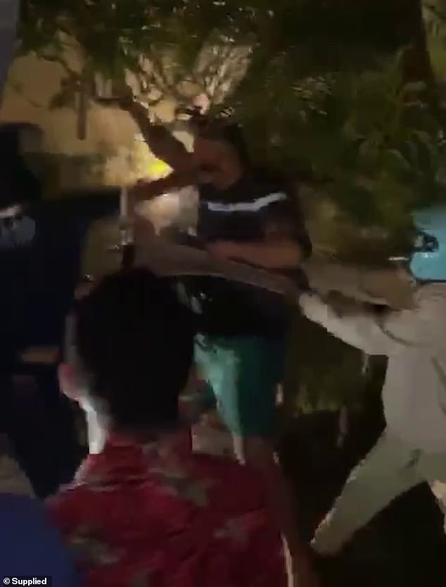 A security guard wearing an Atlas Super Club t-shirt can be seen throwing a wild punch at one of the men