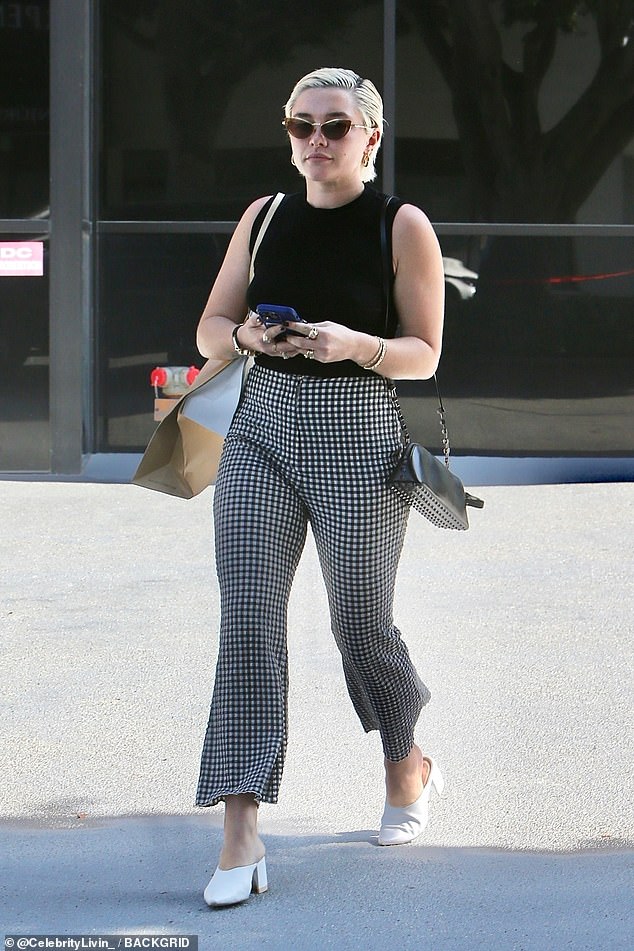 Effortlessly stylish: Florence Pugh looked effortlessly chic as she stepped out in Los Angeles on Tuesday.  The 27-year-old Don't Worry Darling actress put on a stylish show in a black sleeveless top and plaid pants as she went shopping solo in Beverly Hills.